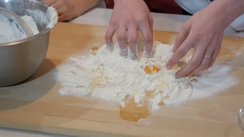 Kneading the dough on the table. Egg in dough Stock Footage 95831321
