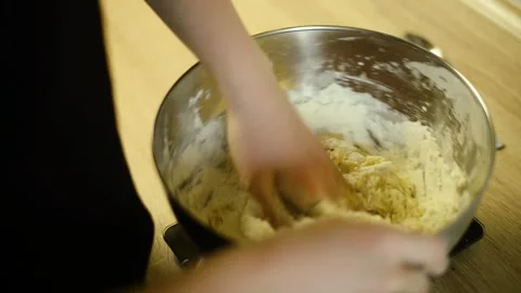 Kneading raw dough with flour by hands inside a deep metal bowl Video stock 342704077