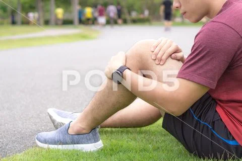 Knee Injuries. Young sport man holding knee with his hands in pain after suff Stock Photos