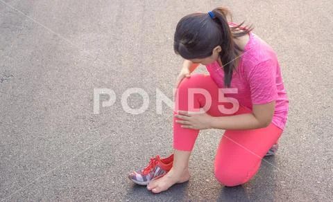 Knee Injuries. Young sport woman holding knee with her hands in pain after su Stock Photos