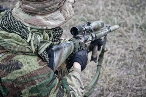 Kneeling commando army soldier marksman over shoulder view Stock Photos