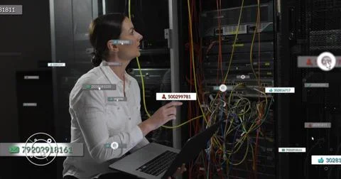 Kneeling IT tech in white shirt connecting colorful cables using laptop at Stock Photos