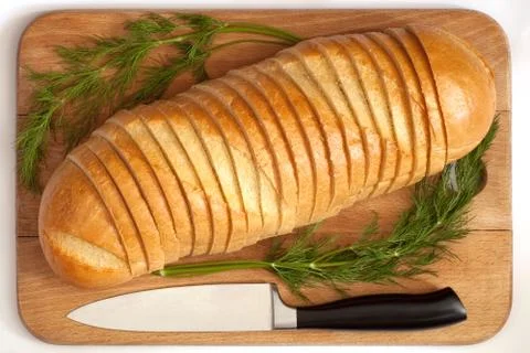 Knife and bread on a board Stock Photos