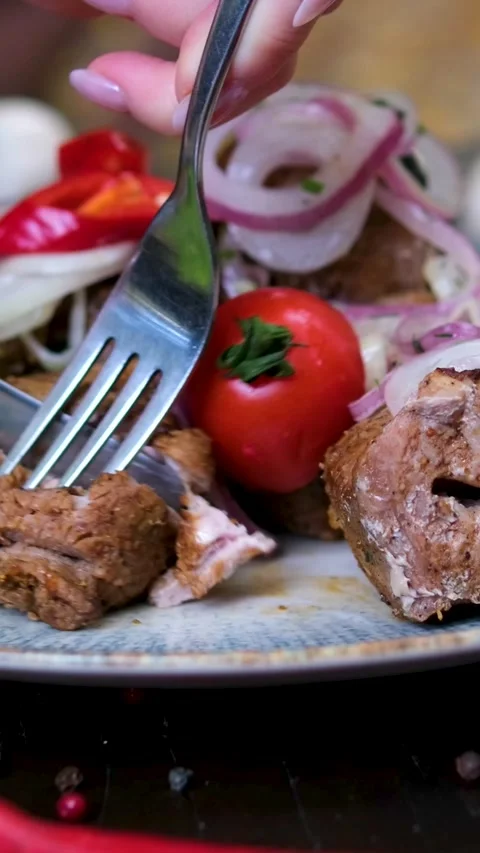 Knife and fork to cut and eat hands are cutting a meat steak on the prep table Stock Footage 323530342