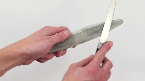 Knife and whetstone in the hands of a man. Hand sharpening a knife Video stock 73094336