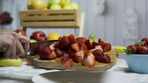 Knife being used to scrape cut up strawberries onto plate, closeup Stock Footage 341026618