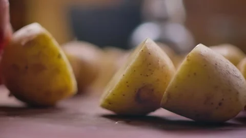 A Knife Blade Cutting a Fresh Young Potato in Half Stock Footage 315417520