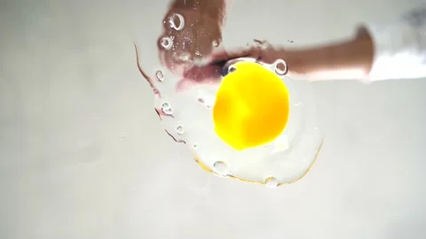 The knife breaks the egg and falls on the pan Stock Footage 130667772