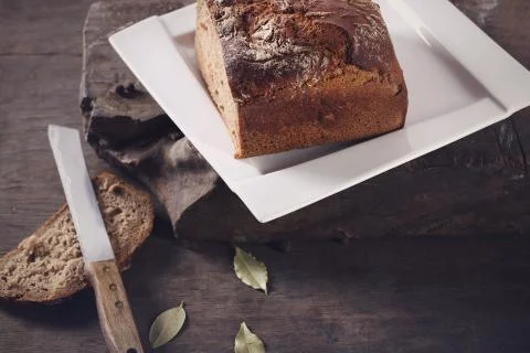 Knife with brown bread on a plate Stock Photos