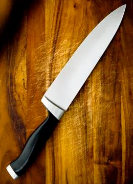 Knife on chopping board Stock Photos