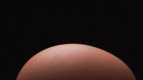 Knife cracks a fresh egg on black background Stock Footage 72414574