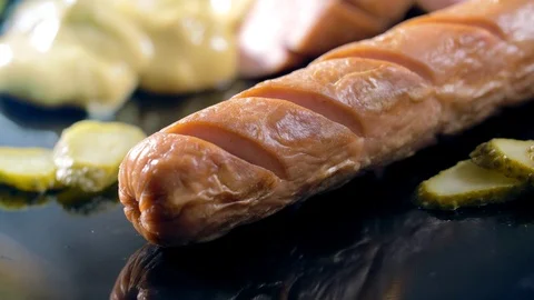 A knife cuts a bratwurst during the breakfast. Very closeup shot Stock Footage 69811145