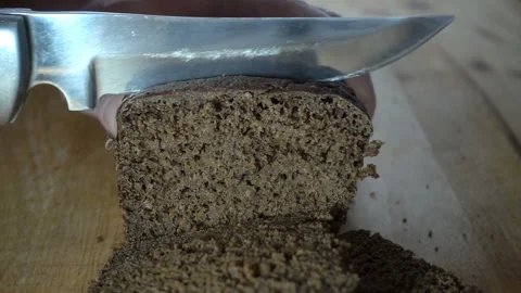 Knife cuts brown bread in slow motion Stock Footage 130493856