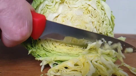 Knife cuts cabbage on a wooden Stock Footage 87877090