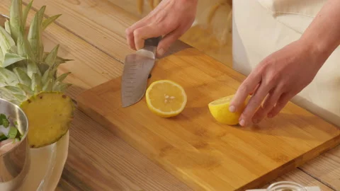 The knife cuts lemon. Hands cut fruit. Fruit cut in half. Cooking Stock Footage 162620634