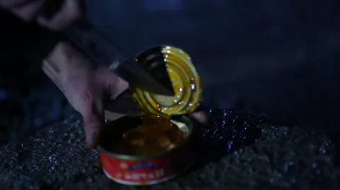 The knife cuts the lid canned Stockbeeldmateriaal 48676676