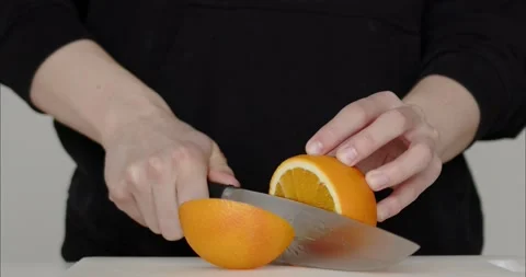The knife cuts an orange. preparation of orange juice. The cook cuts the fruit Stock Footage 235542355