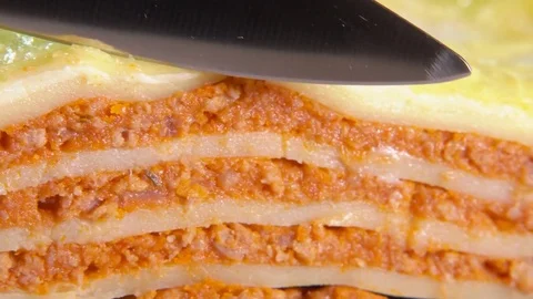 Knife cuts off a piece of the Italian lasagna Stock Footage
