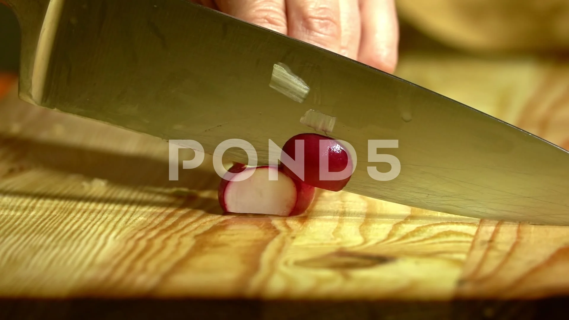 Fresh chopped radishes and a knife on a cutting board on a wooden