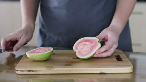 Knife cuts red guava in half. Stock Footage 291613458