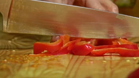 Knife cuts the red pepper in kitchen on wooden board. Close up. Stock Footage 231897244