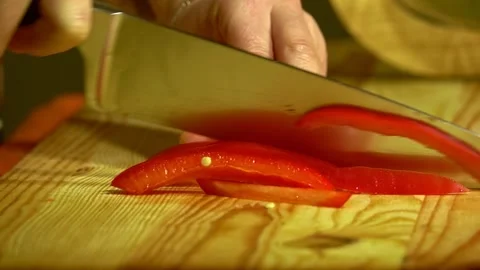 Knife cuts the red pepper in kitchen on wooden board. Close up. Stock Footage 231897256
