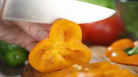Knife cuts the red pepper. Slicing sweet pepper on wooden cutting board. 스톡 동영상 149026352