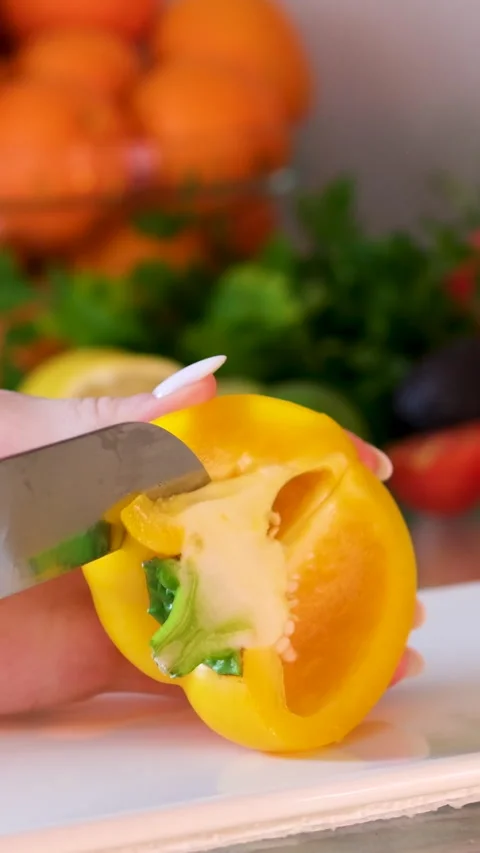 Knife cuts the red pepper. Slicing sweet pepper on wooden cutting board. Male Stock Footage 302073832