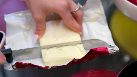 Knife cuts off a slice of Butter. Close-up, shallow dof. Stock Footage 301290105