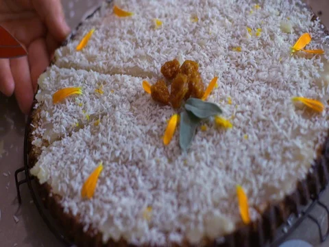 Knife cuts slice of coconut iced cake with dates and raisins Stock Footage 81459712