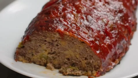 Knife cuts a steaming slice of delicious meatloaf Stock Footage 311060264