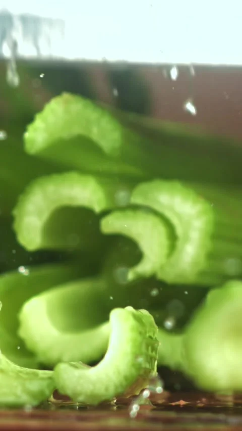 The knife cuts through the fresh sprinkled celery. Filmed on a high-speed camera Stock Footage 335322692