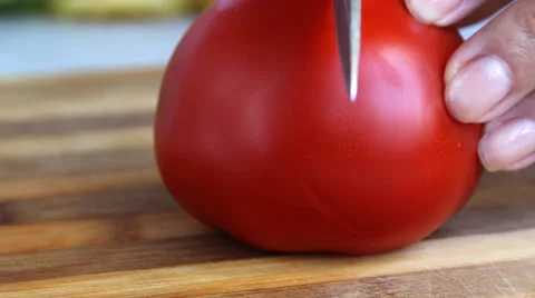 Knife cuts  tomato on the board closeup Stock Footage 64996674