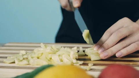 Knife cuts the yellow pepper. Slicing sweet pepper on wooden cutting board. C Stock-Footage 112774928