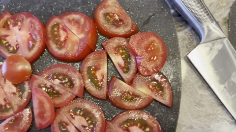 A knife is on a cutting board with a tomato on it 스톡 동영상 282298186