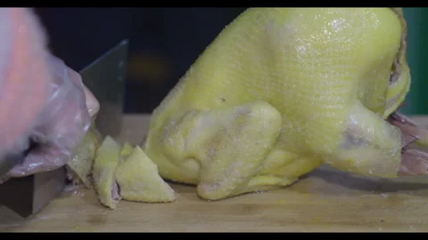 Knife cutting cooked chicken into pieces, close-up, no face Stock Footage 329684875