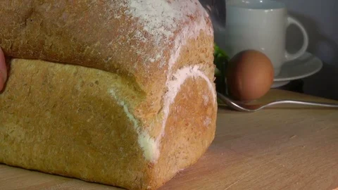 Knife cutting off a loaf grain bread Stock Footage 72294496