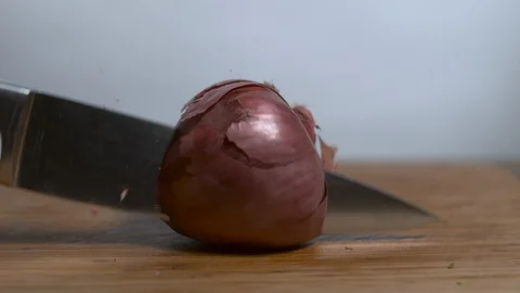 Knife cutting onion in two halves in slow motion Stock Footage 100008603