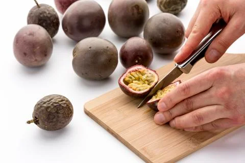 Knife Cutting A Passion Fruit Into Halves Stock Photos