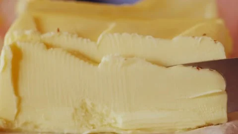Knife cutting of a piece of butter Stock Footage 211387194
