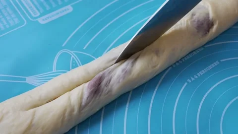 Knife Cutting Raw Dough Roll with Filling on a Blue Baking Mat Video stock 333822120