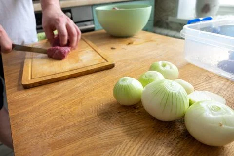 Knife is cutting raw meat. Chef is cooking pork. Ingredient of high-calorie d Stock Photos