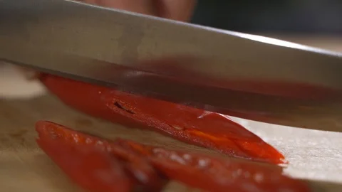 Knife cutting red chilli pepper on wood Stock Footage 125504546