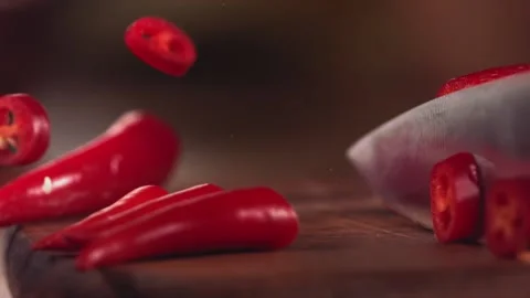 Knife Cutting Red Chilli Pepper on Wood in Slow Motion Stock Footage 169342225
