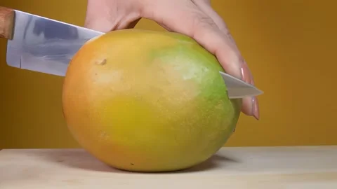 Knife Cutting a Ripe Mango in Half Freshness and Vitamins Stock Footage 334337666