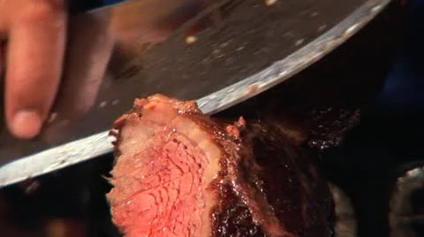 Knife cutting a slice of cooked red meat Stock Footage 11527883