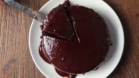 Knife cutting slice of fresh baked dark chocolate hot cake Stock-Footage 121702220