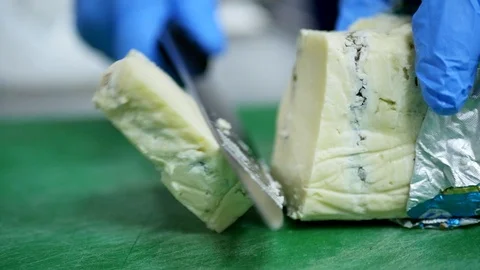 Knife cutting soft cheese on green board Stockbeeldmateriaal 118534810