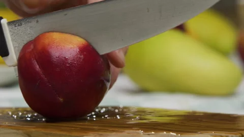 Knife cutting through peach and person breaking it into two - closeup shot Stock Footage 341235901