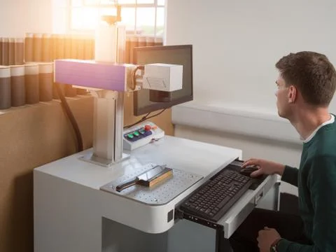 Knife factory worker using computer keyboard to operate laser cutting equipment Stock Photos